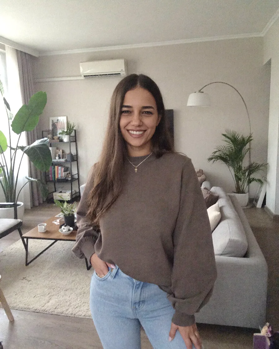 Moni at home in a knitted sweater